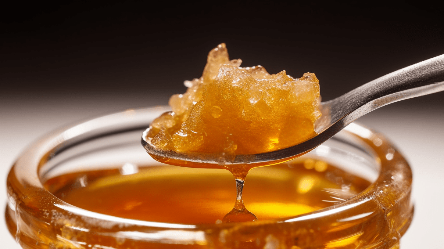 A spoon is lifting a crystallized honey out of a jar, against a dark background.